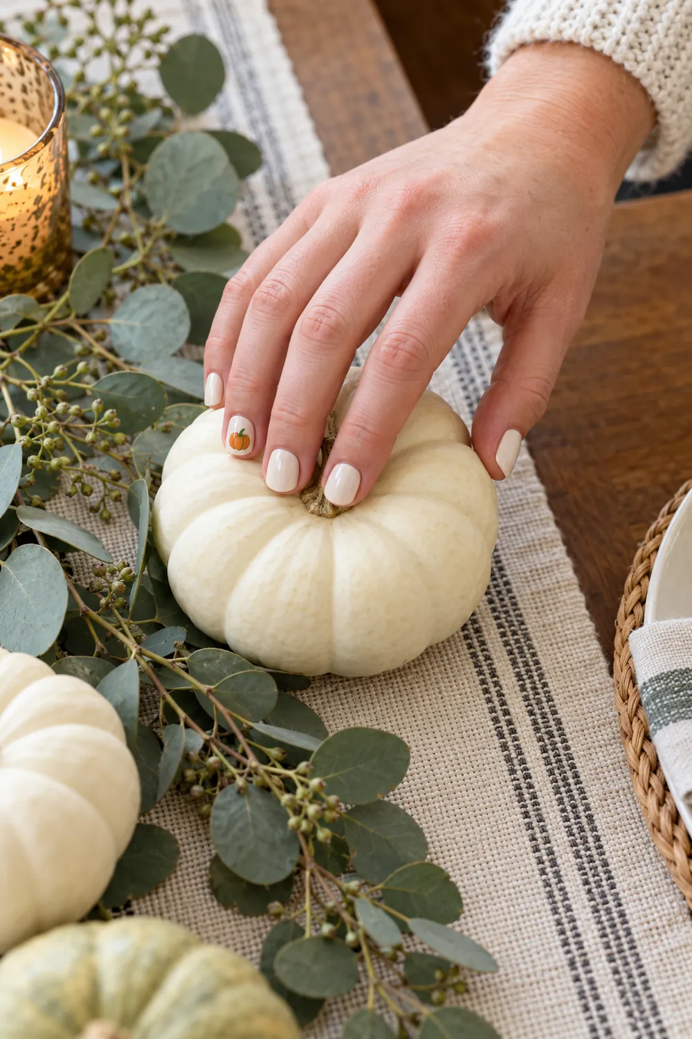 Short cream nails with a small orange pumpkin on the accent nail